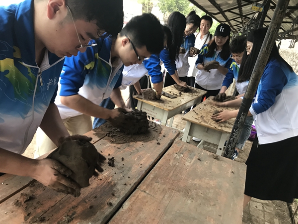 来自黑龙江省中医药大学的志愿者为学生们准备泥塑材料.jpg
