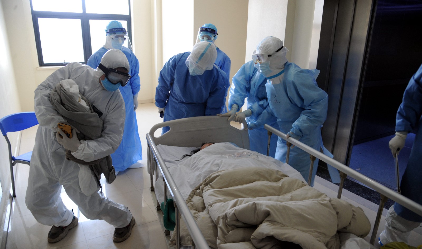 武汉协和医院西院隔离病房内一名新冠肺炎孕产妇剖腹产产下 一名女婴，推出手术室后，孕妇的丈夫抱着新出生的婴儿兴奋地给妻子看.jpg