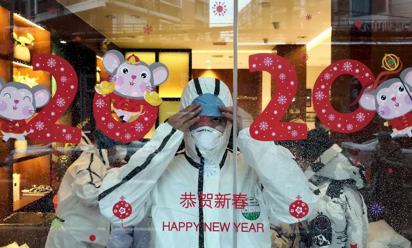 2月14日，武汉运七宾馆内，刚抵达武汉的黑龙江第四批援鄂医疗队队员对着冰棺的窗户练习防护服的穿戴.jpg